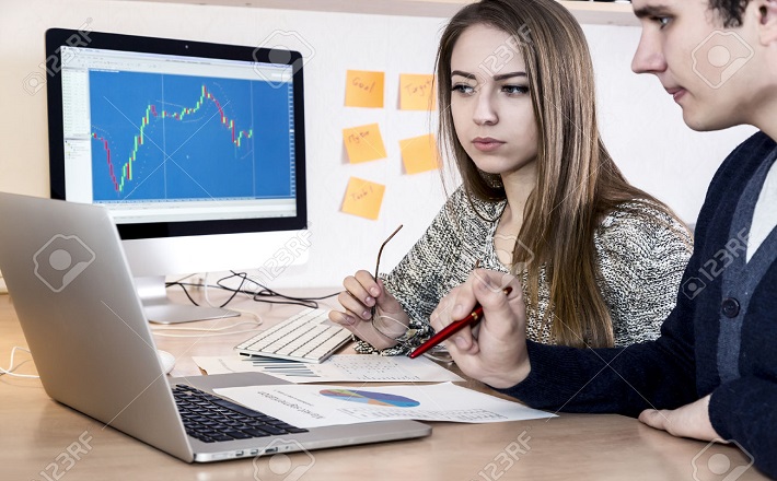 Young man and woman looking at computer screen